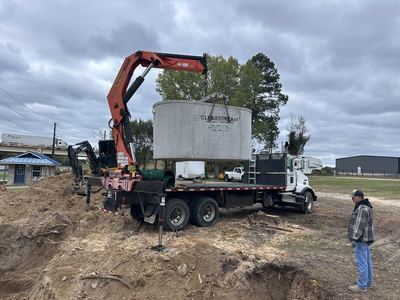 Concrete treatment tank arriving by crane truck