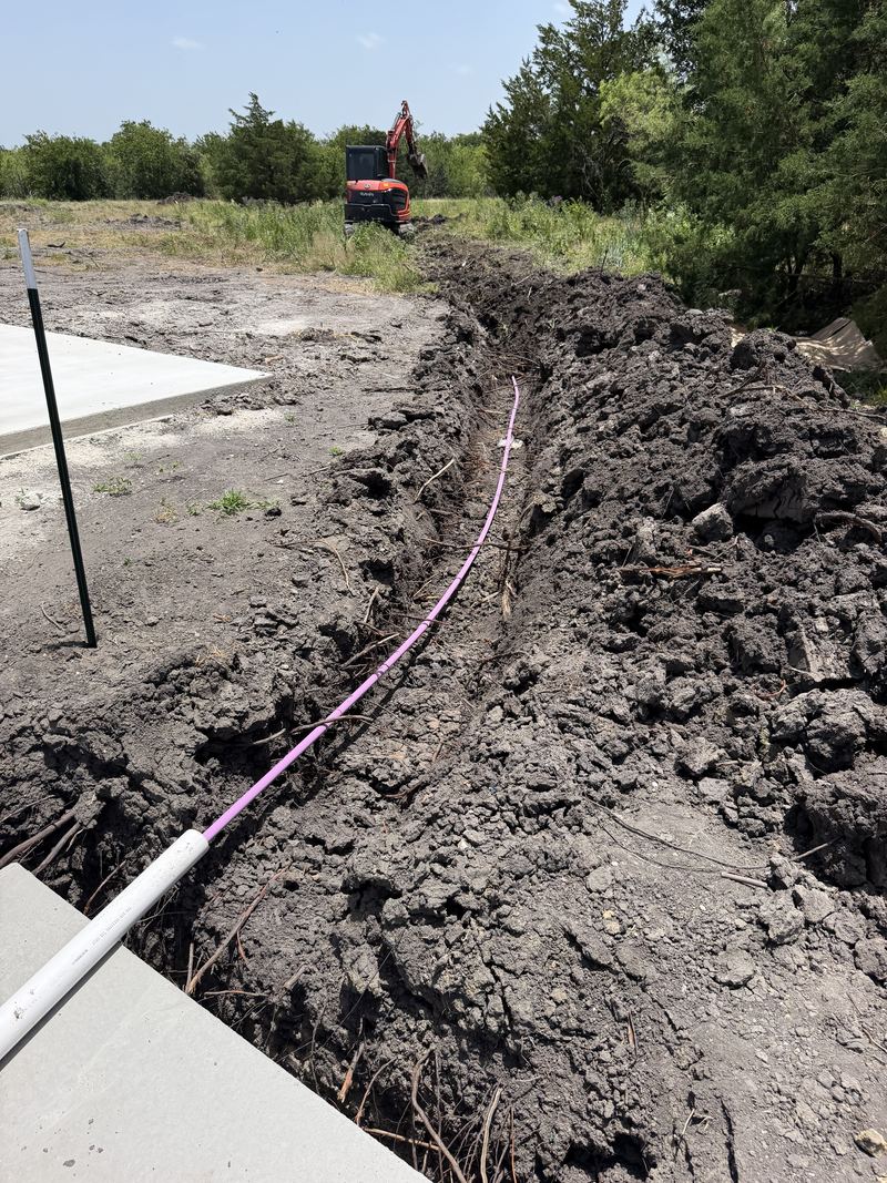 Supply line run in trench beside the slab